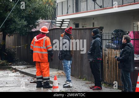 Oakland, USA, 05/01/2023, Bewohner der Wohnung stehen vor ihrem Haus. Seit Januar 4 ist in der San Francisco Bay Area ein starker Sturm aufgetaucht. Mehrere Städte waren von dem starken Sturm betroffen, darunter San Francisco, San Jose, Oakland, Alameda, Daly City, Santa Cruz, Berkeley, Half Moon Bay. Während des Sturms wurden zahlreiche Menschen verletzt und evakuiert. Es gab mindestens eine Person, die durch den Sturm starb und die Bäume fielen. In Oakland stürzte ein großer Eukalyptusbaum auf ein Apartmenthaus in der Lynde Street. Es geschah am frühen Morgen am 5. Januar und Bewohner der A Stockfoto