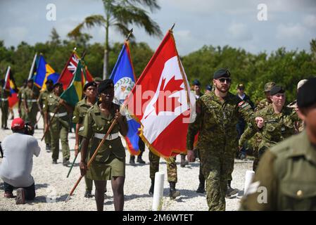 Mitglieder der Belize Defence Force verlassen das Feld mit den Flaggen der teilnehmenden Länder nach der Eröffnungszeremonie für Tradewinds 2022 in Belize City, Belize, am 7. Mai 2022. Tradewinds soll die Fähigkeit der Region zur Eindämmung, Planung und Reaktion auf Krisen erweitern und die regionale Ausbildungskapazität und Interoperabilität erhöhen. Stockfoto