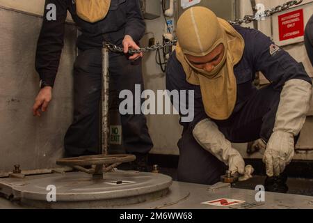 220507-N-CY569-1010 MEDATERANIAN SEA (7. Mai 2022) Machinist's Mate Fireman Makhi Thomas, aus Los Angeles, Hunde nach unten schlüpfen während einer Generalquartierübung an Bord des Flugzeugträgers USS Harry S. Truman der Nimitz-Klasse (CVN 75), 7. Mai 2022. Die Harry S. Truman Carrier Strike Group befindet sich in einem geplanten Einsatz in den USA Sechster Flottenbereich zur Unterstützung der Interessen der USA, Verbündeten und Partner in Europa und Afrika. Stockfoto