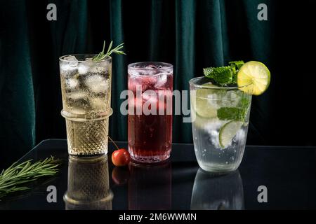 Drei lebendige und funkelnde alkoholische Punsch ist perfekt für die Weihnachtsfeier. Bunte Cocktails in Gläsern. Frische Feiertagsgetränke Stockfoto