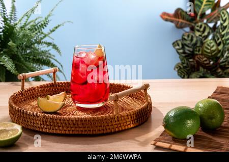 Erdbeercocktail mit Eis auf einem Weidenkorb. Beliebtes, helles, erfrischendes Alkoholgetränk. Erfrischende Sommergetränke mit Humor Stockfoto