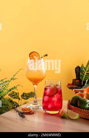 Erdbeercocktail mit Eis und Tequila-Cocktail bei Sonnenaufgang auf einem Weidenkorb. Beliebte helle, erfrischende alkoholische Getränke. Stockfoto