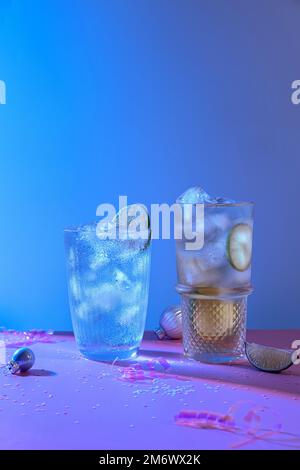 Zwei kräftige und funkelnde alkoholische Punsch sind perfekt für die Weihnachtsfeier. Bunte Cocktails in Gläsern. Frische Feiertagsgetränke. Stockfoto