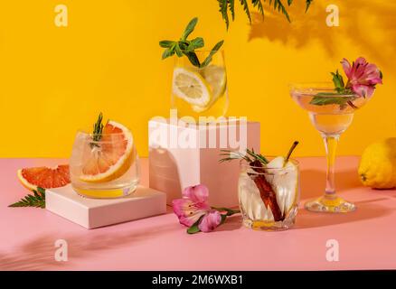 Harte Seltercocktails mit verschiedenen Früchten: Birne, Grapefruit, Zitrone. Erfrischende, farbenfrohe Sommergetränke auf gelbem Hintergrund. Stockfoto