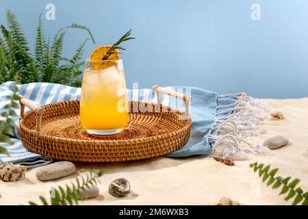 Tequila-Cocktail bei Sonnenaufgang auf einem Korbblech am Strand mit weißem Sand. Sommerurlaub und Reisekonzept. Exotische Sommergetränke Stockfoto