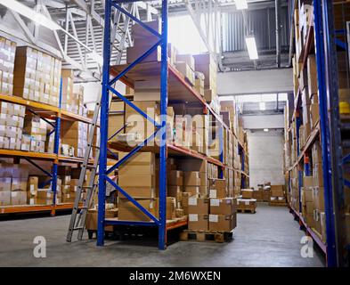 Gestapelt und bereit für die Lieferung. Große Lagerregale mit darauf verpackten Kisten. Stockfoto