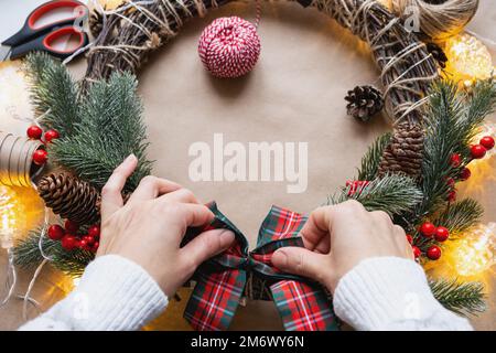 Einen Weihnachtskranz mit eigenen Händen machen. Feiertagsvorbereitung, Hausdekoration, Neujahr Stockfoto