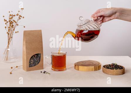 Bio-Teemarkierung und Verpackungsmodell. Leere Teepackung mit Tee. Kraftpapierpackung mit Fenster und leerem Platz Stockfoto