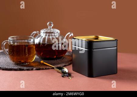 Schwarze Metallverpackung für Tee. Teemarkierung und Verpackungsmodell. Leere Teeverpackung mit Tee, um dein Branding zu zeigen Stockfoto