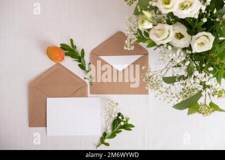 Vorlage für Hochzeitseinladungskarte auf weißem Hintergrund. Leere Grußkarten und Umschlag. Elegant dekorierter Tisch bei einer Hochzeit Stockfoto