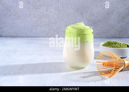 Matcha-Tee. Latte mit grünem Eistee im Glas. Grüner Tee Dalgona, ausgepeitschter Grean Tee mit Milch. Gesundes veganisches Getränk, aus der Nähe Stockfoto