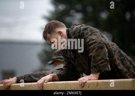 USA Marinekorps 2. LT. Steven Eckenberg, Offizier der Network Support Section, 1. Marine Logistics Group, aus Wheaton, Illinois, klettert während der Iron Mike Challenge 2022 in der Basic School auf Marinekorps Basis Quantico, Virginia, 7. Mai 2022 über eine Mauer. Die Teilnehmer des Marine Corps haben eine Strecke von 20 km zurückgelegt und dabei mehrere Herausforderungen hinsichtlich physischer und zentraler Fähigkeiten bewältigt. Stockfoto