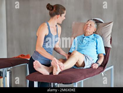 Sie hilft ihren Patienten, stark und gesund zu bleiben. Ein Senior bei einer Physiotherapiesitzung. Stockfoto