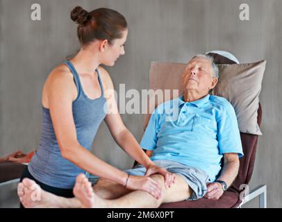 Sie hilft ihren Patienten, stark und gesund zu bleiben. Ein Senior bei einer Physiotherapiesitzung. Stockfoto