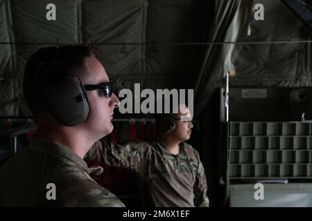 Staff Sgt. Garrett Huntoon, 374. Logistik-Bereitschafts-Geschwader, Betreiber des Treibstoff-Transportsystems, links, Und Senior Airman Kristopher Corpus, 374. LRS Kryogene Lagertechniker, schauen Sie aus den Türen der Frachtrampe eines 36. Airlift Squadron C-130J Super Hercules vom Yokota Air Base, Japan, während es auf einer Landebahn am Clark Air Base, Philippinen, am 7. Mai 2022 fährt. Zwei C-130J-Flugzeuge und zwei F-16-Kampfflugzeuge von der 80. Kampfgeschwader, Luftwaffenstützpunkt Kunsan, Republik Korea, übten Bodenbetankungsverfahren und demonstrierten agile Kampfkräfte, um die Einsatzbereitschaft aufrechtzuerhalten und Stockfoto