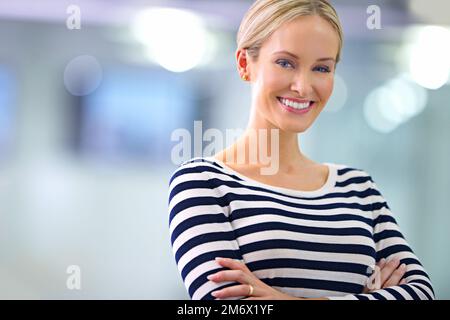 Arbeiten Sie intelligent und glücklich. Porträt einer lächelnden jungen Frau im Büro. Stockfoto