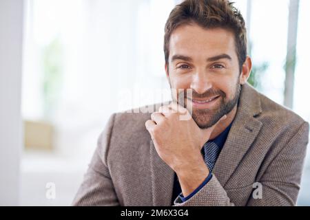 Vertrauen in das Geschäft. Ein junger Mann sitzt in seinem Büro. Stockfoto
