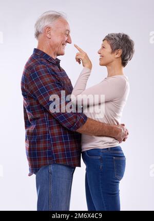 Ich wähle dich immer noch. Studioaufnahme eines liebevollen älteren Ehepaars vor grauem Hintergrund. Stockfoto