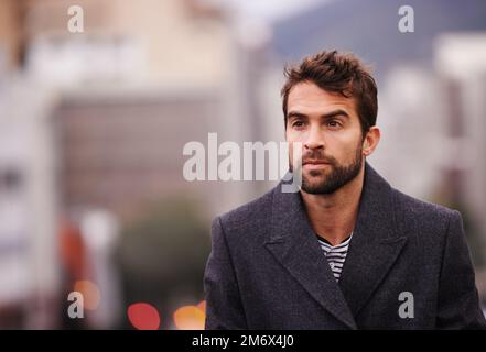 Stadtdesign. Ein gutaussehender junger Mann, der durch die Stadt spaziert. Stockfoto