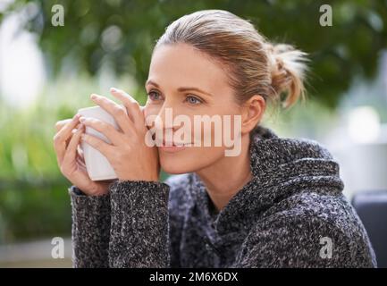 Glück ist eine beruhigende Tasse Güte. Eine attraktive, reife Frau, die ein heißes Getränk in einem Spa genießt. Stockfoto