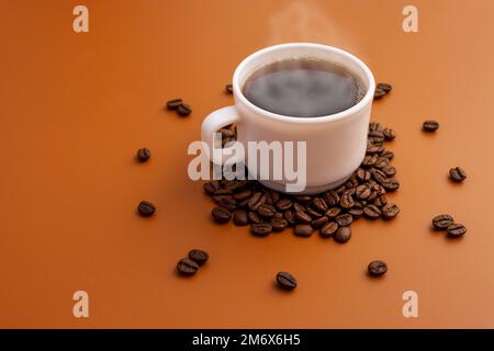 Kaffeetasse und geröstete Bohnen, die als Ziffernblatt auf braunem Hintergrund angeordnet sind Stockfoto