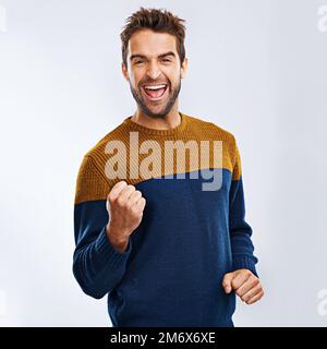 Oh, ja! Studioporträt eines begeisterten jungen Mannes, der einen Erfolg vor grauem Hintergrund feiert. Stockfoto