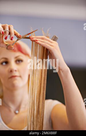 Ich kümmere mich um Spliss-Enden. Eine Friseurin schneidet einem Kunden die Haare. Stockfoto