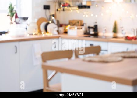 Hintergrund im Innenbereich mit weißer Holzküche mit festlichem Weihnachtsdekor und Chaos, festliches Frühstück, weißer scandi Inter Stockfoto