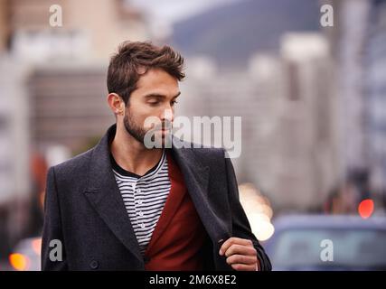 Für den Winter gemacht. Ein gutaussehender junger Mann, der durch die Stadt spaziert. Stockfoto