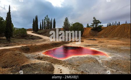 Ein unbekannter Mann, der in der Nähe eines Sees mit verseuchtem, giftigem Wasser spaziert. Verlassene Kupfermine Stockfoto