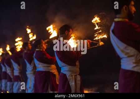 Haridwar, Indien - Okt. 2022: Porträt des männlichen hindu-Priesters, der den Fluss Ganges aarti mit Feuerlicht in der Hand am triveni ghat anbetet, um den Fluss ganga anzubeten. Stockfoto