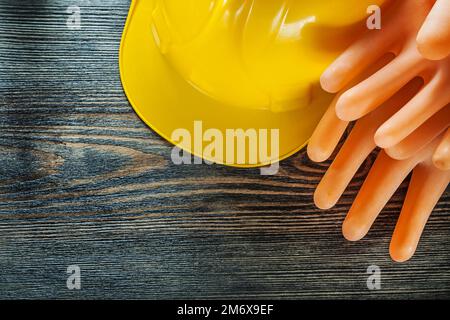 Isolierhandschuhe für Bauhelme auf Holzbrettern. Stockfoto