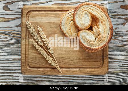 Schnitzbrett rollt Weizenohren auf altmodischer Holzoberfläche. Stockfoto