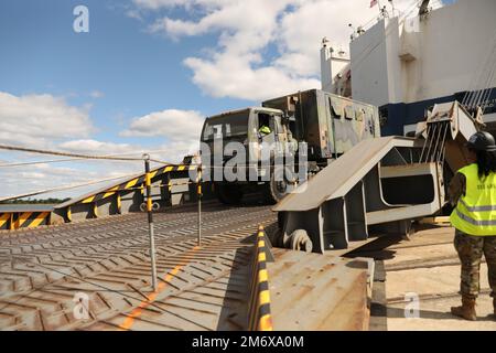 Staff Sgt. Destiny Crews, der 3. Division Sustainment Brigade Mobilityoffizier, der verantwortlich ist, beobachtet, wie ein leichtes, mittelschweres taktisches Fahrzeug das Schiff verlässt, während ein Hafen-Fort-Betrieb an der Joint Base Charleston Naval Weapons Station in Charleston, South Carolina, am 8. Mai 2022 stattfindet. Der Hafen-Fort-Betrieb wird durchgeführt, um die dem DSB vom Einsatzgebiet der Zentralkommandos zugeteilte Ausrüstung zurückzugeben, nachdem die Einheit 9 Monate lang zur Unterstützung der Operation Spartan Shield eingesetzt wurde. Stockfoto