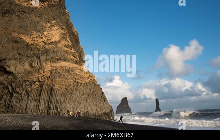 Die Leute besichtigen den schwarzen Sandstrand von Reynisfjara in Vik I Mydral South Iceland. Atlantik gefährliche windige Wellen Stockfoto