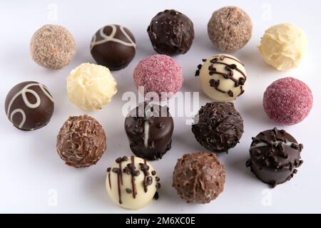 Foto von verschiedenen runden Schokoladenbonbons aus der Nähe auf weißem Hintergrund Stockfoto