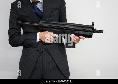 Geschäftsmann mit einem Maschinengewehr zu kämpfen Stockfoto