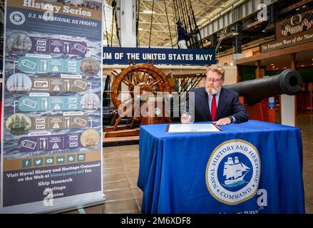 220509-N-OL781-1019 WASHINGTON NAVY YARD (9. Mai 2022) Patrick C. Burns, Deputy Director of Naval History and Heritage Command, unterzeichnet eine Proklamation im National Museum of the U.S. Navy, die den 10. Mai 2022 zu den USA erklärt Navy Original Six Fregates Day. Der NHHC feierte den 225. Jahrestag des Starts der ersten der sechs Fregatten (USA), die durch das Gesetz von 1794 mit dem Titel „Act to Providing a Naval Armament“ (Gesetz zur Bereitstellung einer Marinewaffen) genehmigt wurden. Die Genehmigung versprach dem Präsidenten die ersten Kriegsschiffe der neuen Navy: Vereinigte Staaten (gestartet 1797), Constellation (1797), Constitution (1797), Con Stockfoto