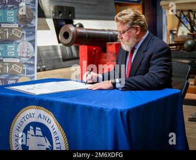 220509-N-OL781-1015 WASHINGTON NAVY YARD (9. Mai 2022) Patrick C. Burns, Deputy Director of Naval History and Heritage Command, unterzeichnet eine Proklamation im National Museum of the U.S. Navy, die den 10. Mai 2022 zu den USA erklärt Navy Original Six Fregates Day. Der NHHC feierte den 225. Jahrestag des Starts der ersten der sechs Fregatten (USA), die durch das Gesetz von 1794 mit dem Titel „Act to Providing a Naval Armament“ (Gesetz zur Bereitstellung einer Marinewaffen) genehmigt wurden. Die Genehmigung versprach dem Präsidenten die ersten Kriegsschiffe der neuen Navy: Vereinigte Staaten (gestartet 1797), Constellation (1797), Constitution (1797), Con Stockfoto