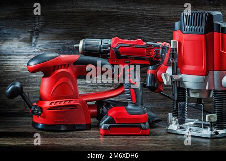 Elektrische Handwerkzeuge rotes Holz Schleifen Maschinenkabel Stichsäge Akku-Bohrer und kleine Tauchfräsmaschine tragbarer Mini-Holzfräser auf Jahrgang Stockfoto
