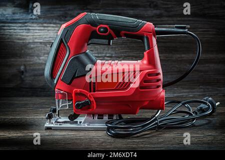 Elektrische Handwerkzeuge, kabelgebundene Stichsäge auf altem Holzhintergrund Stockfoto