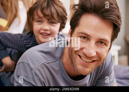 Ich verbringe schöne Zeit mit seinem Jungen. Porträt von Vater und Sohn, die zu Hause verspielt sind. Stockfoto