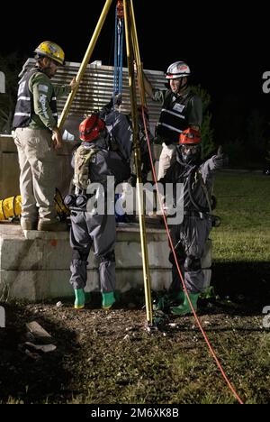 Ingenieure, die der 526. Engineer Construction Company aus Fort Stewart, Georgia, zugeteilt wurden, lassen ein Teammitglied in einen kleinen Zementtunnel absenken, um ein simuliertes Opfer zu holen, am 9. Mai 2022. Die Soldaten sind Teil einer mehrteiligen Heimatnotfallübung namens Guardian Response 22. Die Übung, die im Muscatatuck Urban Training Area (Ind.) durchgeführt wird, soll die Fähigkeiten verbessern, ihre Fähigkeiten bei der Suche und Rettung in der Stadt verbessern und die Bereitschaft der Armeeeinheiten verbessern, die dem Chemischen, biologischen, radiologischen und nuklearen Reaktionsunternehmen des Verteidigungsministeriums zugewiesen sind. Stockfoto