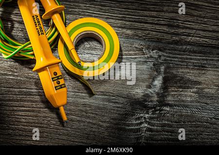 Isolierband für Elektrokabeltester auf altem Holzbrett. Stockfoto