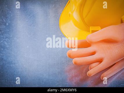 Isolierende Handschuhe Bauhelm auf metallischem Hintergrund. Stockfoto