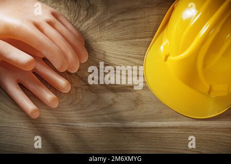 Isolierende Handschuhe, die Helme auf Holzbrettern bauen. Stockfoto