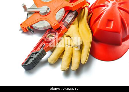 Isolierte Bauwerkzeuge Roter Helm Handschuhe Level großes Maßband Stockfoto