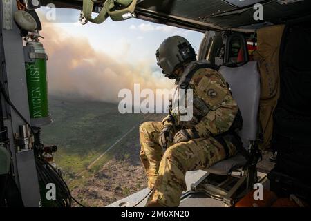 BELIZE CITY, Belize (9. Mai 2022) U.S. Army Sgt. Austin Gutherman, ein Crewchef, der dem 1. Battalion 228. Aviation Regiment Joint Task Force Bravo zugewiesen wurde, überprüft während einer medizinischen Evakuierungsübung über Belize City, Belize, während der Übung Tradewinds 2022, 9. Mai 2022, auf Flugkontakte. Tradewinds 2022 ist eine multinationale Übung, die darauf abstellt, die Fähigkeit der karibischen Region zu erweitern, Krisen zu mildern, zu planen und darauf zu reagieren, die regionale Ausbildungskapazität und Interoperabilität zu erhöhen, neue und bestehende Standardarbeitsverfahren (SOPs) zu entwickeln und zu verfeinern sowie die Fähigkeit zur Verteidigung exklusiver eg zu verbessern Stockfoto