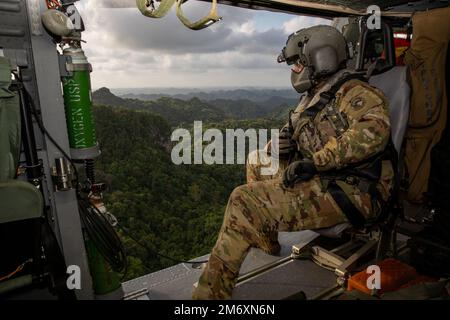 BELIZE CITY, Belize (9. Mai 2022) U.S. Army Sgt. Austin Gutherman, ein Crewchef, der dem 1. Battalion 228. Aviation Regiment Joint Task Force Bravo zugewiesen wurde, überprüft während einer medizinischen Evakuierungsübung über Belize City, Belize, während der Übung Tradewinds 2022, 9. Mai 2022, auf Flugkontakte. Tradewinds 2022 ist eine multinationale Übung, die darauf abstellt, die Fähigkeit der karibischen Region zu erweitern, Krisen zu mildern, zu planen und darauf zu reagieren, die regionale Ausbildungskapazität und Interoperabilität zu erhöhen, neue und bestehende Standardarbeitsverfahren (SOPs) zu entwickeln und zu verfeinern sowie die Fähigkeit zur Verteidigung exklusiver eg zu verbessern Stockfoto