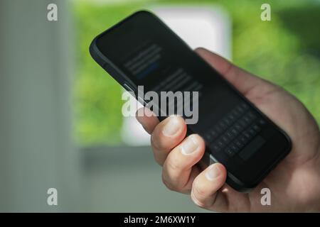 Mann sendet Textnachrichten und sms mit Smartphone Kommunikation Textnachricht mit Mobiltelefon Online-Chat Stockfoto
